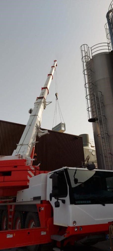 Kranen der ein demontiertes Lüftungsgerät vom Dach hebt