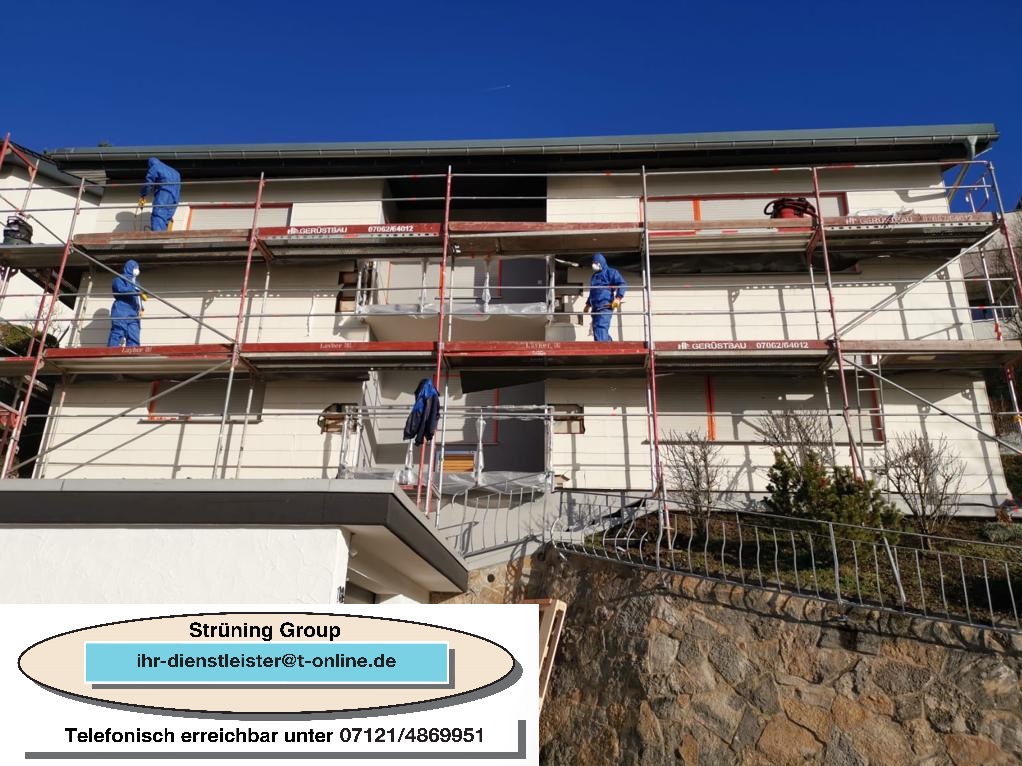 Demontage von Eternit Bauarbeiter in Blaulatschen renovieren ein Gebäude mit Gerüst unter blauem Himmel.